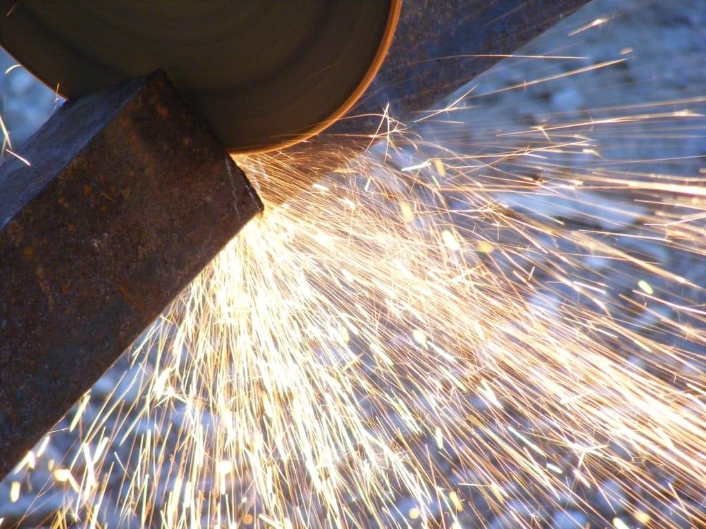 An angle grinder cutting steel, throwing sparks.